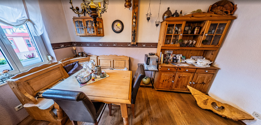 Frühstücksraum der Pension Kluge mit Holzmöbeln, Dekoration und Kaffeemaschine in warmer Atmosphäre.