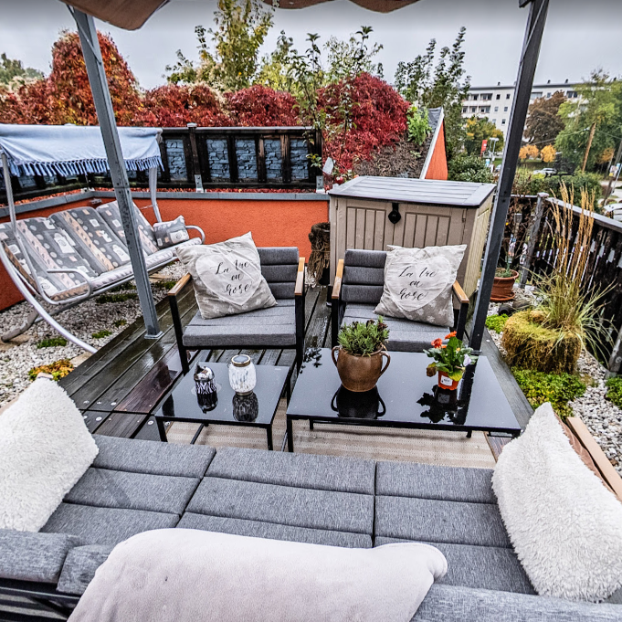 Sonnenterrasse der Pension Kluge in Freiberg mit gemütlicher Sitzlounge und Ausblick in den Garten.