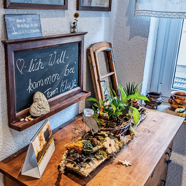 Willkommensbereich der Pension Kluge in Freiberg mit liebevoller Dekoration und Tafel „Herzlich willkommen“.