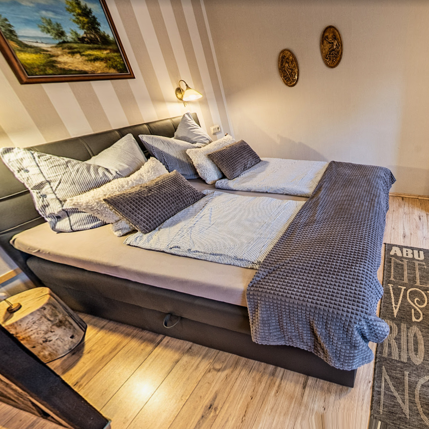 Doppelzimmer der Pension Kluge mit zwei Einzelbetten, warmem Licht und moderner Ausstattung.